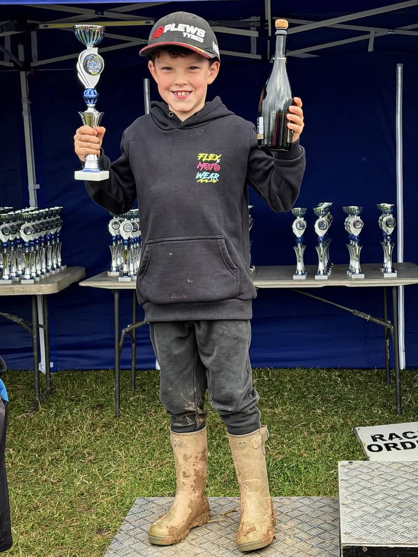 Henry Wilcox with a trophy and podium bottle after a win
