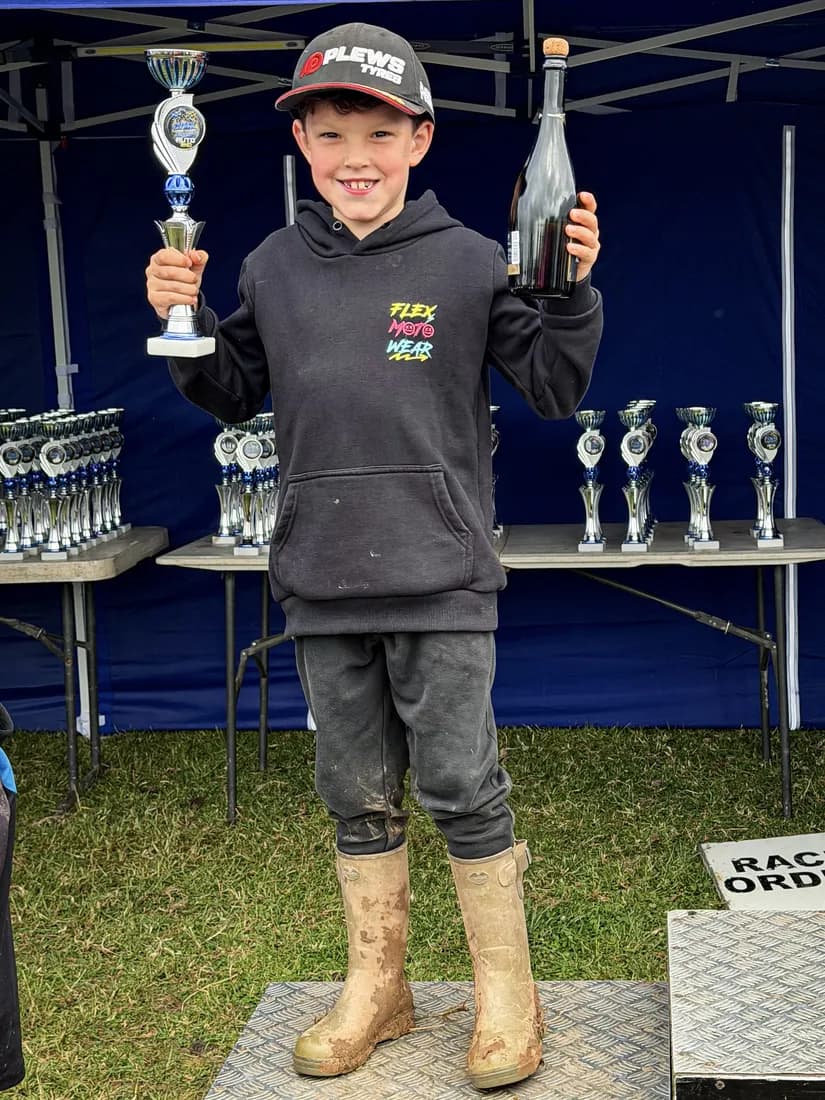 Henry Wilcox with a trophy and podium bottle after a win