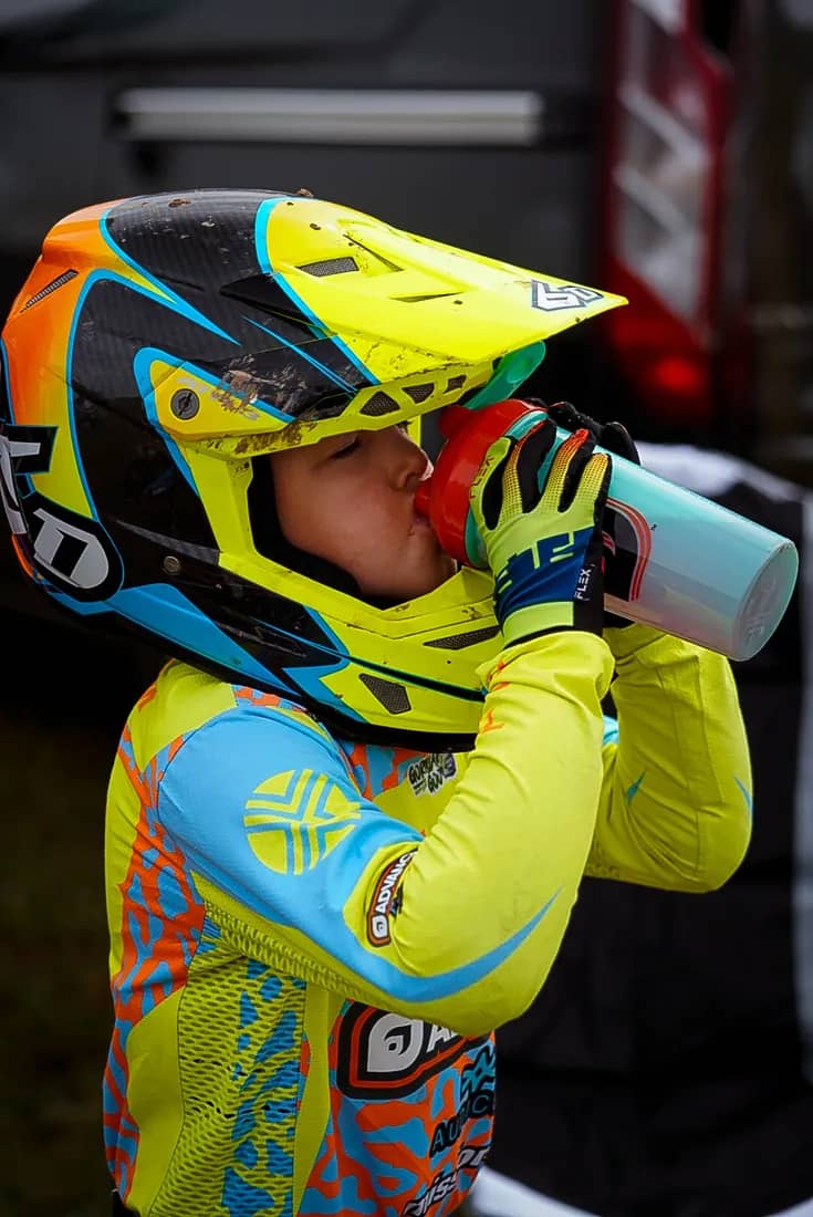 Henry Wilcox taking a drink between motos in full race kit