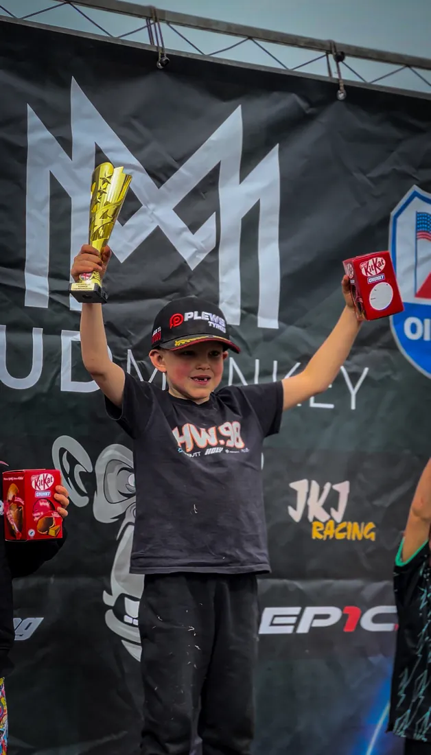 Henry Wilcox on the podium holding a trophy