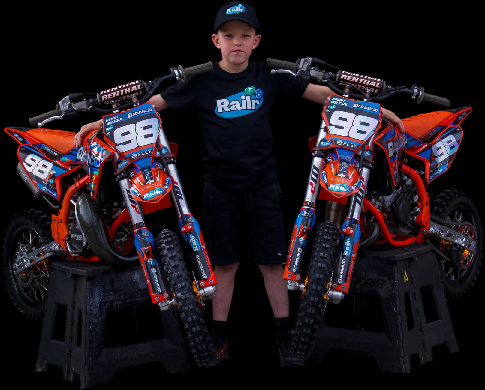Henry Wilcox between his two #98 KTM race bikes